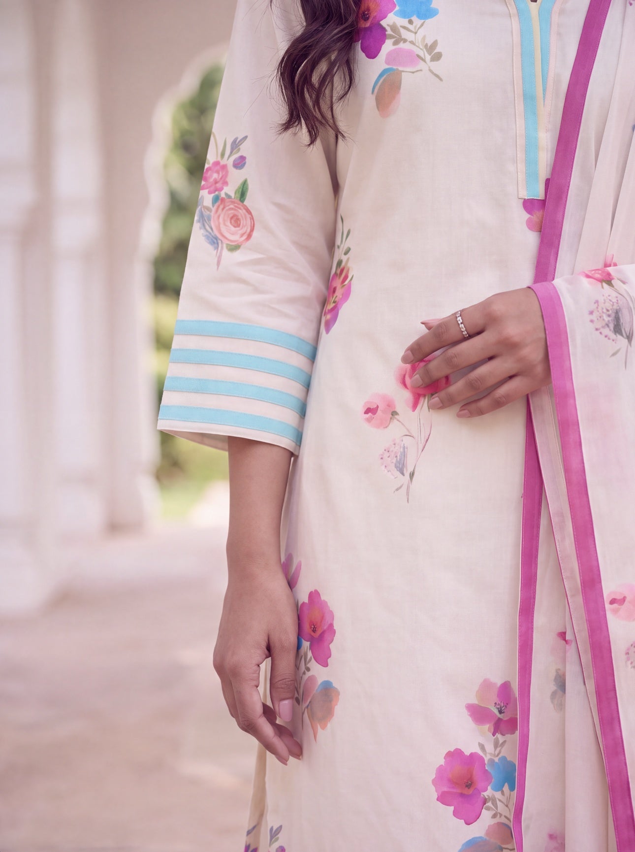 Close-up of aqua striped sleeve cuff and floral print on ivory kurta