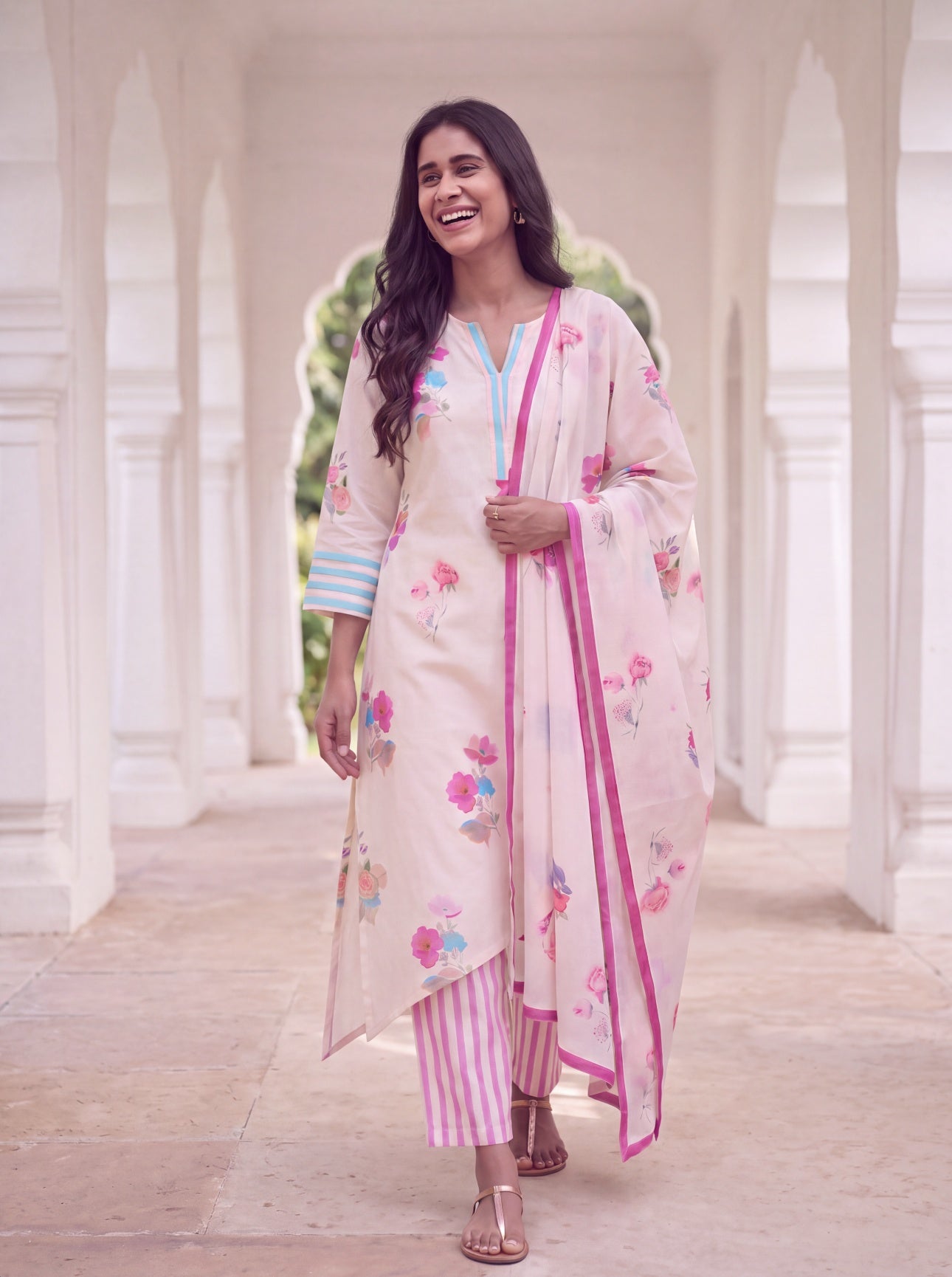 Woman in ivory floral kurta set with pink striped pants and floral dupatta