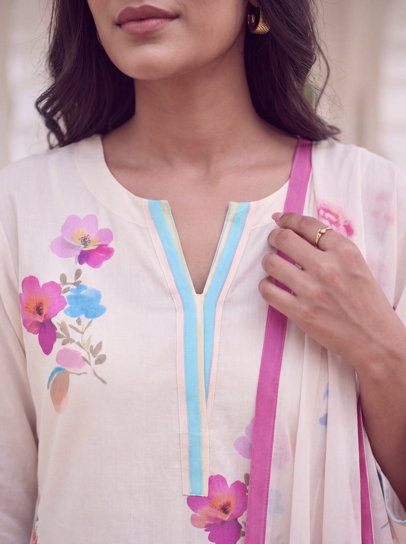Close-up of notched V neckline with aqua piping on floral kurta